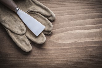 Paint scraper on protective glove