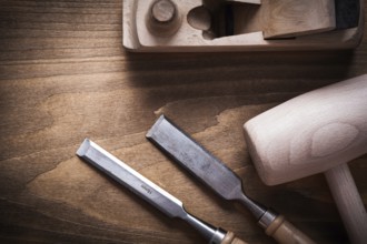 Wooden mallet shaving plane firmer chisels on wood board construction concept