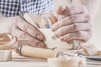 Woodworkers plane in hands of carpenter very close up