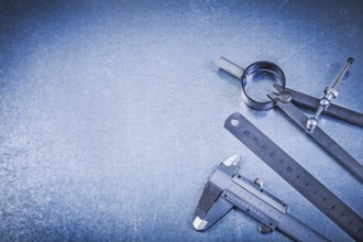 Metal construction drawing compass ruler caliper on metallic background
