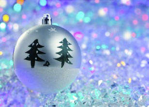 Christmas silver bauble on colorful glowing ice cubes