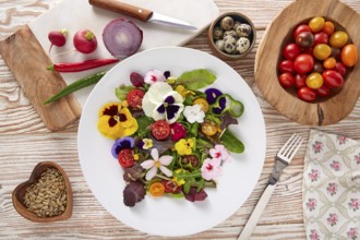 Edible flowers salad in a plate with ingredients