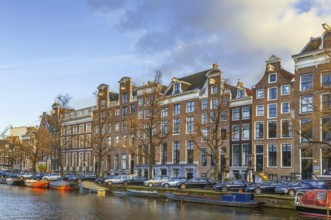 View of Amsterdam canal with historic houses and boat, Netherlands