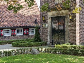 Entrance area of a brick building with well-tended garden and autumn foliage, losser, Netherlands
