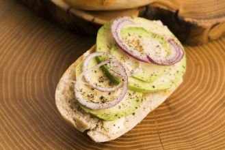 Sandwich with avocado, red onion, salt and herbs