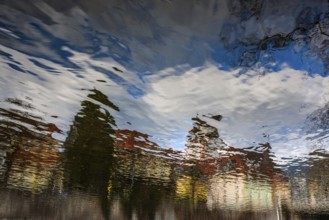 Buildings reflected in the river Mur, Leoben, Styria, Austria, Europe