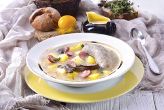 A polished Easter soup with homemade white sausages and mushrooms