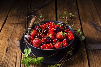 Bowl with different fruits such as strawberry, red currant, and cherry
