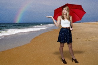 A beautiful young woman holding an umbrella in the rain