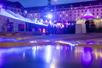 Winter festival on the Altmarkt, reflection of the festival in the new fountain in the evening,