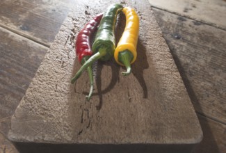 Hot peppers on wooden kitchen cutting board