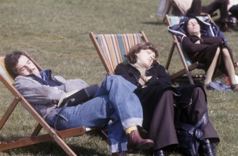 London 1982. A London park and people are sitting in chairs enjoying the sunny sping day. Credit
