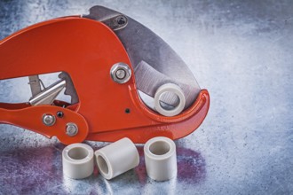 Pipe cutter water tube on metallic background construction concept