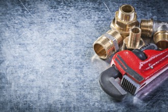 Monkey wrench brass nipple hose connectors on metallic background plumbing concept