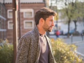 One handsome young man in urban setting in European city, standing