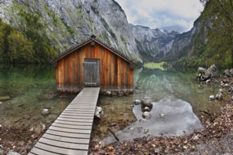 Cloudy day at Lake Koenigssee. Boathouse connected to the coast wooden decking. Clouds and