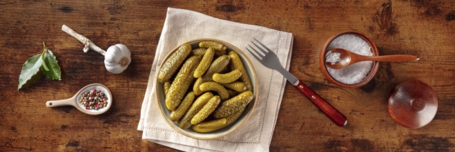 Pickled cucumbers with salt, pepper, garlic, and bay leaf panorama. Fermented food. Homemade canned