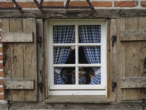 Rustic window with blue and white chequered curtains in a wooden frame, weseke, münsterland,