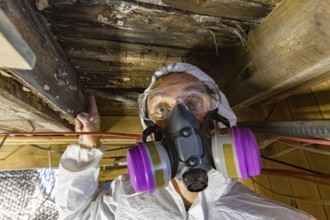 A close up view of an environmental quality inspector wearing respirator, pointing towards