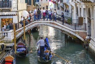 Tourists taking gondola, the traditional Venetian boat, on canal in Venice, Italy, Europe