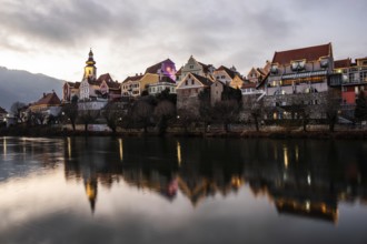 Christmas illuminated house facade of Frohnleiten reflected in the river Mur, Frohnleiten, Styria,