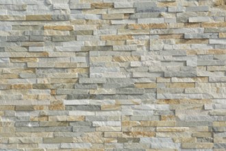 Thin natural stones form a pattern in a stone wall