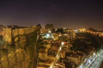 Night view of Porto funicular railway, house roofs with illumination