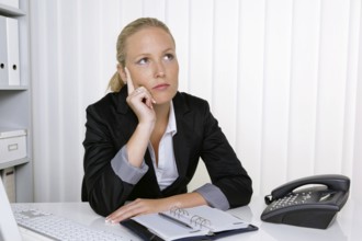 A secretary in the office at her daily work, 35 years, Thoughtful studio shot, Federal Republic of