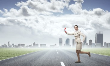 Woman running outdoor with vintage red phone. Expressive secretary with telephone on background