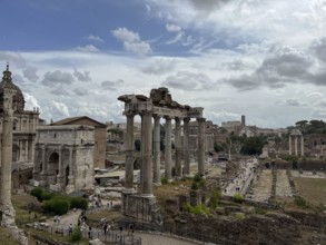 Wide view of ancient ruins with columns under a cloudy sky, Rome, Italy, Europe