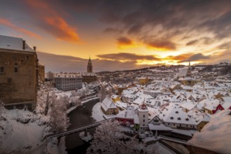 Winter view of Cesky Krumlov, picturesque houses under the castle with snow-covered roofs. Narrow