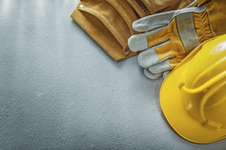 Tool belt safety gloves building helmet on concrete background