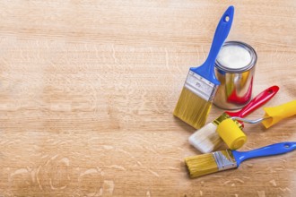 Organized copyspace set of paint brushes roller and can on wooden board