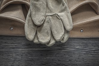 Tool belt safety gloves on wooden board
