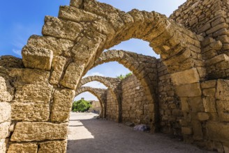 Picturesque ruins of the ancient city of Caesarea. Israel. Sunny spring day. Arched passage -