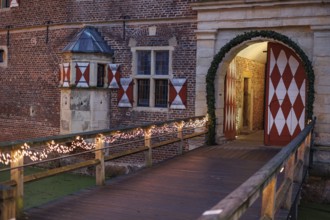 Castle bridge with lights leads to a large entrance gate, Rasfeld, Münsterland, North