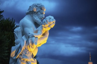 Marble statue of a man holding a small child at the castle in Karlsruhe beautiful lightened in the