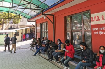 Kathmandu, Nepal, 16 March 2020: People wearing protecting masks outside a hospital, waiting for