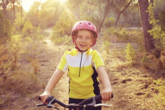 Kid girl biker in mountain bike MTB at mediterranean forest
