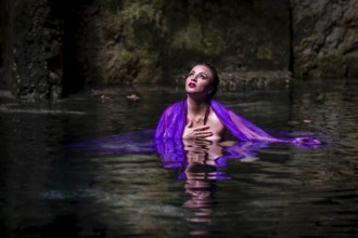 A beautiful nude latin model enjoys the gorgeous water in a colorful cenotes in Yucatan Merida,
