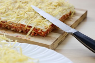 Salt cake with cheese and red paprika on wooden table with knife