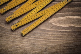 Yellow wooden meter on wood board top view construction concept