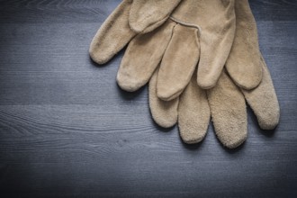 Two safety gloves on dark wooden board