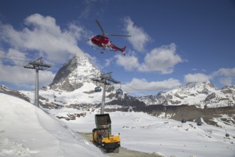 Zermatt, Switzerland, April 13, 2017: A helicopter loading concrete at a construction site in the