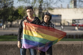 LGBT couple holding LGBT raiwbow flag