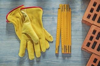 Leather safety gloves red bricks wooden meter on wood board bricklaying concept