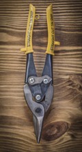Sharp metal steel cutter on vintage wooden board construction concept