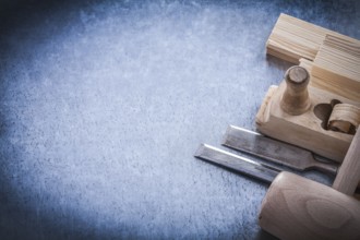 Wooden planer hammer bricks firmer chisels on metallic background copyspace