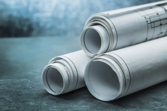 Rolls of blueprints on metalic background