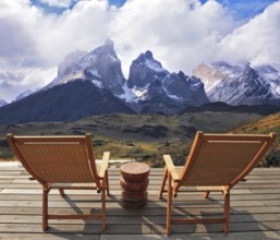 Comfortable lounge chairs on wooden platform for rest and observation. Gorgeous snow-covered rocks
